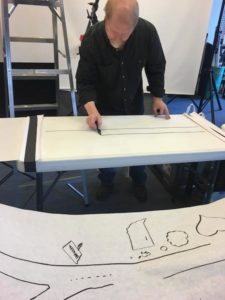 Behind the scenes, artist draws an image for a whiteboard product video.