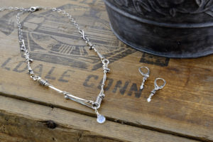 Product photos of handcrafted metal jewelry necklace and matching earrings by Lil Bird Design.