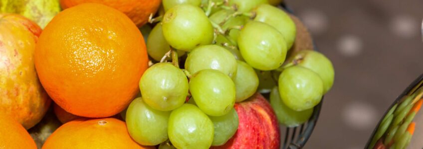 A still life fruit display of oranges, grapes, bananas, apples and pears. Photo by Miceli Productions. Title image for {{brizy_dc_image_alt entityId=