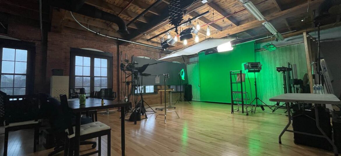 Photo of Miceli Productions inside filming space with a green screen set-up.